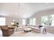 An open-concept living room featuring neutral tones, large windows, and carpeted floors at 4925 Cedar Forest Dr, Charlotte, NC 28226