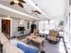 Bright sunroom featuring comfortable seating, a ceiling fan, television and views of the backyard at 4925 Cedar Forest Dr, Charlotte, NC 28226
