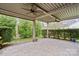 Serene back patio with stone pavers, ceiling fans, and manicured hedges at 499 Granite Lake Ct, Denver, NC 28037