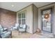 Inviting front porch with comfortable seating and a decorative wreath on the glass front door at 499 Granite Lake Ct, Denver, NC 28037