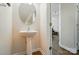 Powder room with pedestal sink and round mirror next to an open doorway at 513 Pate Dr, Fort Mill, SC 29715