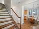 View of the staircase with wooden treads and white risers, leading to a dining area with wood floors at 513 Pate Dr, Fort Mill, SC 29715