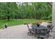 Brick patio with outdoor seating and a view of landscaped backyard with fire pit at 516 Amanda Dr, Weddington, NC 28104