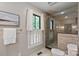Bathroom with tiled walk-in shower, white tile flooring, and a window with a decorative curtain at 516 Amanda Dr, Weddington, NC 28104