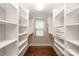 Walk-in closet with wood floors, bright white shelving, hanging rods, and a window for natural light at 516 Amanda Dr, Weddington, NC 28104