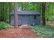 Exterior view of backyard shed, nestled among mature trees, adds storage and character to the landscape at 516 Amanda Dr, Weddington, NC 28104