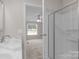 Bathroom featuring double vanity, shower with glass door, and access to bedroom at 5606 S Rocky River Rd, Monroe, NC 28112