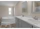 Bathroom featuring double vanity, large soaking tub, and neutral walls at 5606 S Rocky River Rd, Monroe, NC 28112