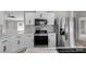 Well-equipped kitchen featuring stainless steel appliances, marble countertops, and white cabinetry at 5606 S Rocky River Rd, Monroe, NC 28112