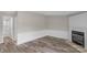Living room featuring neutral walls, wood-look flooring, fireplace and adjacent bath at 5606 S Rocky River Rd, Monroe, NC 28112