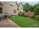 Backyard with green lawn, patio, privacy fence, and mature landscaping at 5917 Bridger Ct, Charlotte, NC 28211