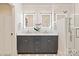 Modern bathroom features a double vanity with illuminated mirrors and glass-enclosed shower at 5917 Bridger Ct, Charlotte, NC 28211