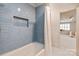 Bathroom with a combination shower and tub, featuring blue subway tile and a window at 5917 Bridger Ct, Charlotte, NC 28211
