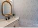 Stylish half bathroom features patterned wallpaper, a gold mirror, and modern vanity at 5917 Bridger Ct, Charlotte, NC 28211