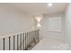 Well-lit hallway featuring a carpeted staircase, stylish light fixture, and neutral decor at 5917 Bridger Ct, Charlotte, NC 28211