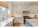 Bright kitchen features custom white cabinets, marble countertops, and stainless steel appliances at 5917 Bridger Ct, Charlotte, NC 28211
