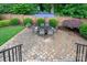 Paver patio with an outdoor dining set under an umbrella, surrounded by lush landscaping at 5917 Bridger Ct, Charlotte, NC 28211