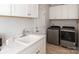 Laundry room with white cabinets and a laundry sink, next to washer and dryer at 602 Compass Dr, Denver, NC 28037