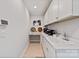 A well lit pantry with built-in desk, sink, and ample white cabinet storage at 602 Compass Dr, Denver, NC 28037