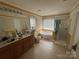 Main bathroom featuring a double sink vanity, soaking tub, and a walk-in shower at 6120 Brightstar Valley Rd, Mint Hill, NC 28227