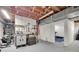Basement with pegboard wall, workbench, tools, American flag, and view into separate room with exercise equipment at 6626 Rocky Falls Rd, Charlotte, NC 28211
