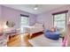 Bright, stylish bedroom with purple walls, hardwood floors, and a large window with a view at 6626 Rocky Falls Rd, Charlotte, NC 28211