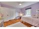 Light-filled bedroom with hardwood floors, purple accents, and ample storage in the closet at 6626 Rocky Falls Rd, Charlotte, NC 28211