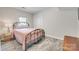 Bedroom with a cozy iron bed frame and light pink quilt, offering a peaceful retreat at 6626 Rocky Falls Rd, Charlotte, NC 28211
