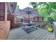 Wooden deck featuring an outdoor dining table with umbrella and bench seating with a view of green trees at 6626 Rocky Falls Rd, Charlotte, NC 28211