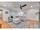 Comfortable living room has a plush sectional sofa, hardwood floors, and natural light from the window at 6626 Rocky Falls Rd, Charlotte, NC 28211