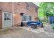 Back patio of a brick home with outdoor seating, patio heater, white door, and a view of lush greenery at 6626 Rocky Falls Rd, Charlotte, NC 28211