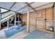 Covered patio space featuring string lights, brick walls, a table and chairs, and blue outdoor rugs at 6626 Rocky Falls Rd, Charlotte, NC 28211