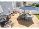 Cozy backyard patio setup with a dining table, seating, an umbrella, grill, and manicured landscaping at 7043 Blakeney Greens Blvd, Charlotte, NC 28277