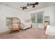 Cozy bedroom with a wicker chair, ceiling fan, neutral color scheme, and natural light at 7043 Blakeney Greens Blvd, Charlotte, NC 28277