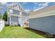 Two-story home with gray siding, white trim, small brick patio, and fenced in yard at 7043 Blakeney Greens Blvd, Charlotte, NC 28277