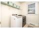 Bright laundry room featuring modern washer, dryer, storage shelves, and a natural light filled window at 7043 Blakeney Greens Blvd, Charlotte, NC 28277