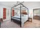 Spacious main bedroom with a four-poster bed and floral print curtains at 7043 Blakeney Greens Blvd, Charlotte, NC 28277