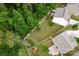Aerial view of the backyard with green lawn, surrounded by woods and a white fence at 7527 Finnigan Rd, Charlotte, NC 28215