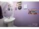 Stylish half bathroom with purple walls and unique decor at 7527 Finnigan Rd, Charlotte, NC 28215