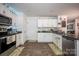 Well-lit kitchen featuring white cabinets and stainless steel appliances at 7527 Finnigan Rd, Charlotte, NC 28215