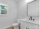 Clean bathroom featuring a white vanity with black hardware, a toilet, and large mirror at 7874 Lucky Creek Ln, Denver, NC 28037