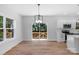 Bright dining area featuring hardwood floors, modern light fixture, and sliding doors to the outdoor deck at 7874 Lucky Creek Ln, Denver, NC 28037