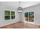 Bright dining room with hardwood floors, modern light fixture, and sliding glass door to a deck at 7874 Lucky Creek Ln, Denver, NC 28037