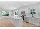 Open-concept kitchen featuring stainless steel appliances, white cabinets, and a breakfast bar at 7874 Lucky Creek Ln, Denver, NC 28037