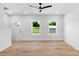 Bright living room featuring hardwood floors, white walls, and two windows providing natural light at 7874 Lucky Creek Ln, Denver, NC 28037