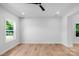 Bright living room featuring hardwood floors, white walls, ceiling fan, and ample natural light at 7874 Lucky Creek Ln, Denver, NC 28037