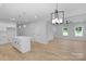 Open concept living space with white walls, modern lighting, and light wood floors at 7874 Lucky Creek Ln, Denver, NC 28037