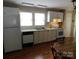 Efficient kitchen with white cabinetry, black appliances, and durable laminate flooring at 809 Ruth Ave, Kannapolis, NC 28083