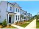 Row of charming white townhouses with black doors and window trim, plus sidewalks and lawn at 8102 Jacey Ln # 24, Huntersville, NC 28078