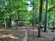 Spacious backyard featuring a fire pit, shed, picnic table, hammock, and a brick path through the lush greenery at 8217 Lansford Rd, Charlotte, NC 28277